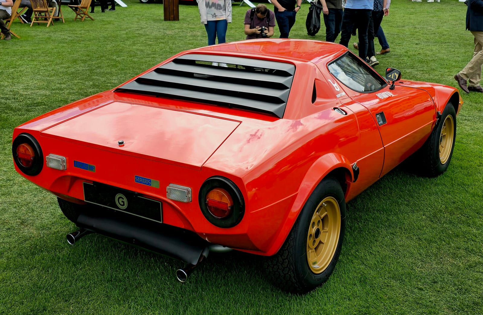 Lancia Stratos HF Stradale rojo visto desde atrás, sobre el césped de un concurso.